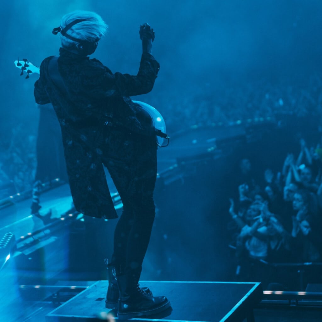 A person standing on a stage with a bass.